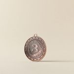 Close-up of a bronze medal with a number three on a plain white background.