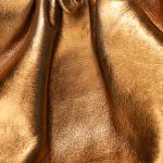 Detailed close-up of shimmering gold fabric, showcasing its luxurious and elegant texture.