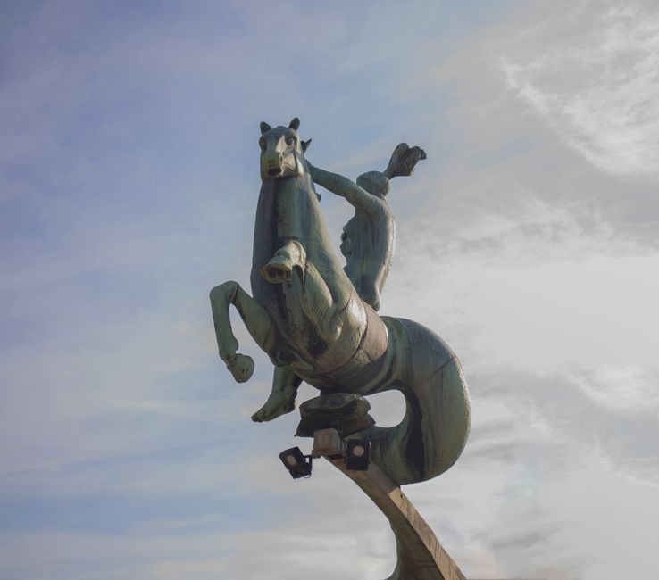 Bronze 1 Outdoor bronze statue of a horse and rider under a cloudy sky, showcasing movement and heritage.